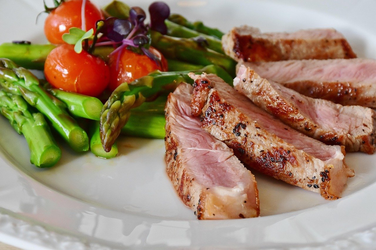 Juicy tender cooked meat medallions plated with herb garnish